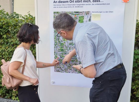 Der für Mobiltät Zuständige erklärt einer Anwohnerin die Bus-58-Strecke